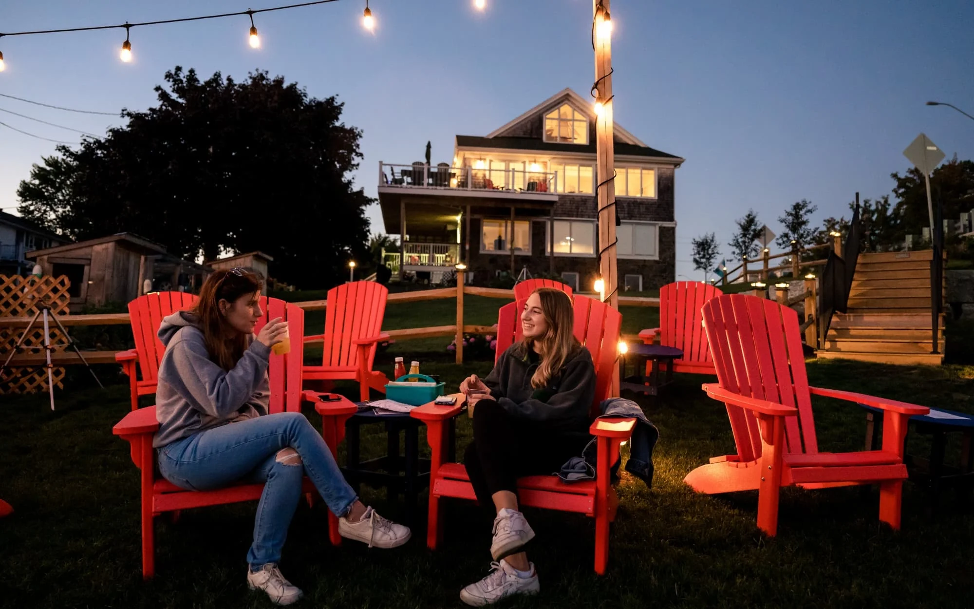 Two women enjoy an evening conversation while seated outside the Buoy Shack.